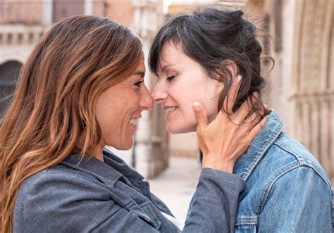 Close de um jovem casal de lésbicas na rua beijando o conceito gay Foto Premium