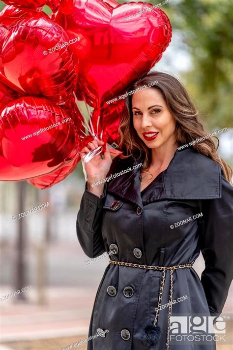 A Beautiful Brunette Model With A Dozen Balloons For Valentines Day Stock Photo Picture And