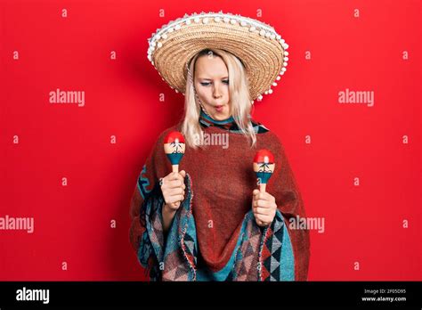 Belle Femme Blonde Caucasienne Portant Poncho Mexicain Festif Et Maracas Faisant Le Visage De