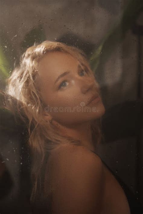 Seductive Blonde In A Black Bikini Poses Behind Glass In A Tropical Shower Stock Image Image