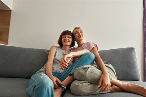 Smiling Lesbian Girls Watching Tv On Sofa At Home Stock Image Image