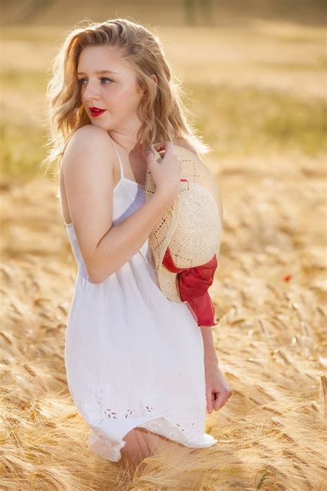 Belle Jeune Fille Blonde Seule Dans La Robe Blanche Avec Le Chapeau De Paille Image Stock