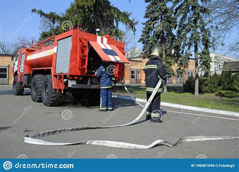 Fireman Set Hoses Out Another One Checking A Water Pump Stock Photo