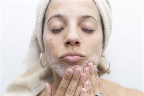 Latina Woman Rubbing Skin Care Cream On Her Face She Has A Towel On Her Head Stock Image