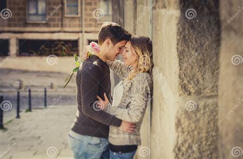 Candid Portrait Of Beautiful European Couple With Rose In Love Kissing