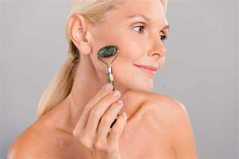 Photo Of Pretty Dreamy Senior Lady Nude Shoulders Doing Lifting Roller Procedures Isolated Grey