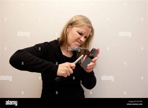 La Mujer Está Decidida A Romper En Su Teléfono Celular Con Un Martillo