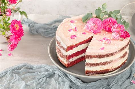 Red Velvet Naked Cake With Fresh Roses And Swiss Buttercream On Kitchen Countertop Stock Photo
