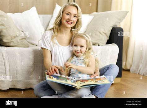Bonne Famille Une Jeune M Re Blonde Lit Un Livre Sa Jolie Fille Tout En Tant Assise Au Sol
