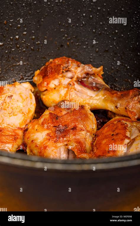 Chicken Legs Marinated With Spices Are Fried In A Cauldron Stock Photo