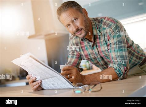Smiling Mature Man Drinking Coffee And Reading Newspaper Stock Photo Alamy
