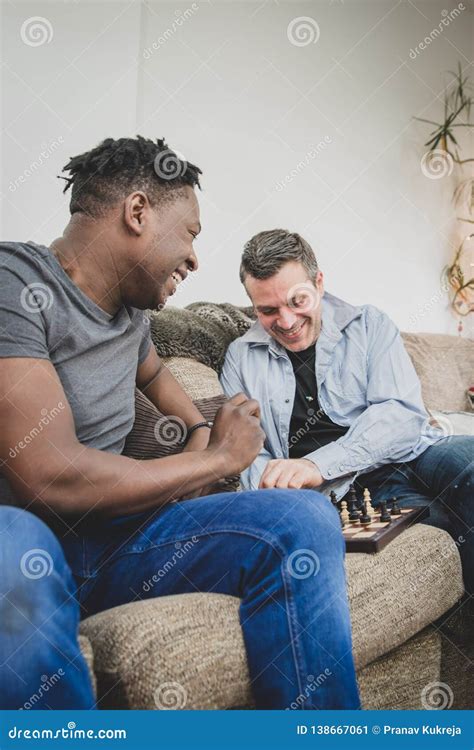 A Gay Couple Enjoying Time Indoors At Home Playing Chess Stock Image Image Of Husband