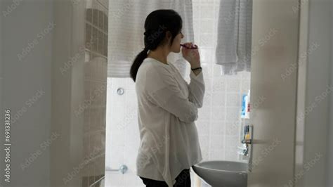 Woman Brushing Teeth In Bathroom Candid Scene Of Person Engaged With