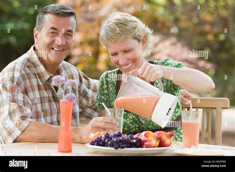Mature Couple Sitting At A Breakfast Table And Smiling Stock Photo Alamy