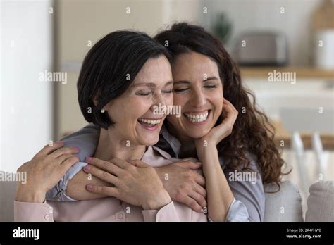 Happy Positive Mature Mother And Adult Kid Woman Hugging Cuddling Stock Photo Alamy