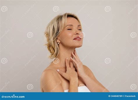 Happy Smiling Attractive Half Naked Middle Aged Blonde Woman Covered In Towel Touching Her Neck