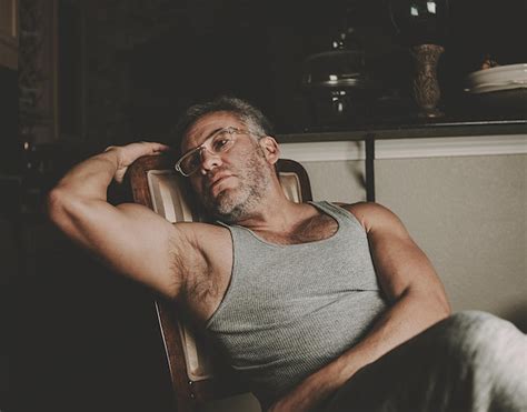 Premium Photo Thoughtful Muscular Mature Man Sitting On Chair At Home