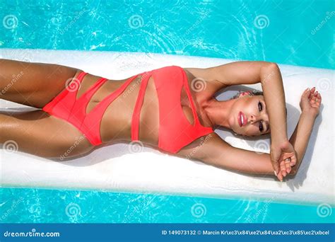 La Mujer Atractiva Elegante En El Bikini Anaranjado En El Cuerpo Delgado Y Bien Proporcionado