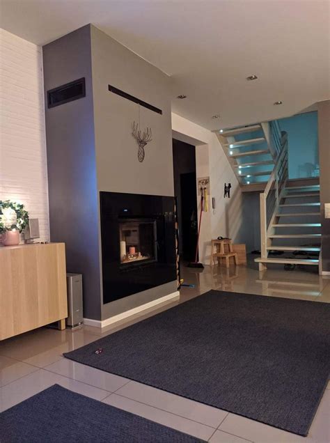 A Living Room With A Fire Place Next To A Stair Case In The Wall And A