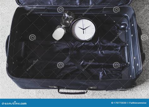 Time To Travel Or Delay During A Trip Empty Suitcase With Clock And