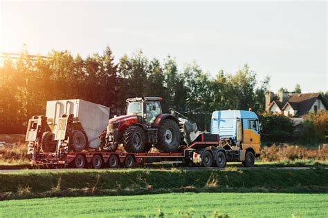 Premium Photo | The semi truck is hauling farm equipment on a flatbed ...