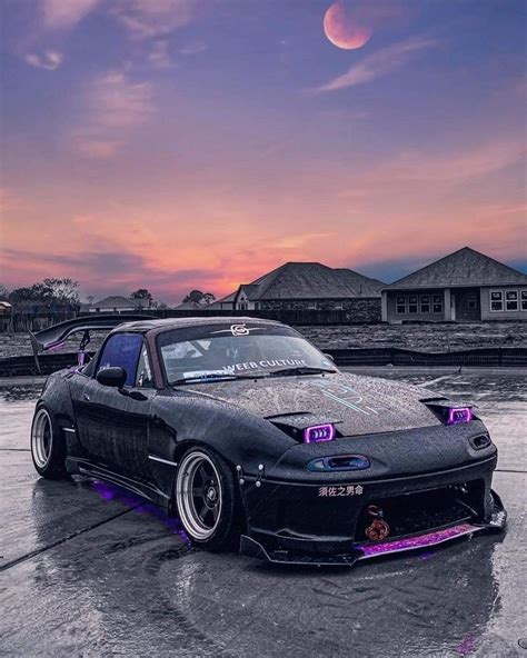 A Black Car With Purple Lights Parked In The Parking Lot