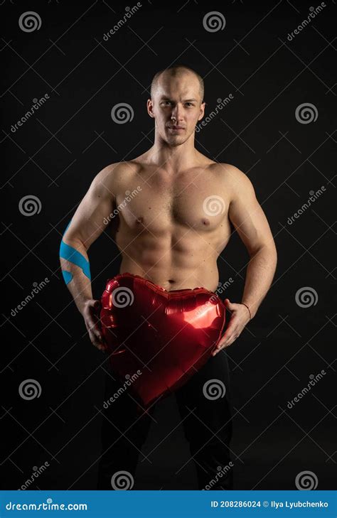 Athletic Man Holding A Red Heart A Naked Balloon In His Hand For A Day Of Velentin Pumped Up