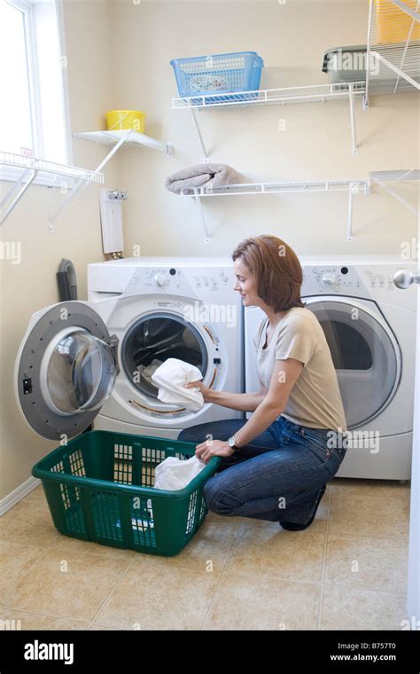 Woman loading front loading washing machine with cloth diapers ...