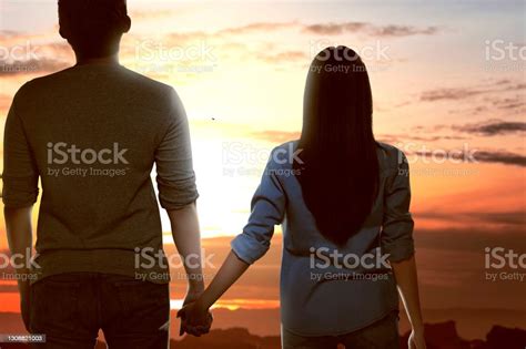 Rear View Of Asian Couple Standing And Holding Hands Each Other Stock