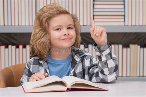Portrait Of School Boy Reading Book In Library Kids Development Learn