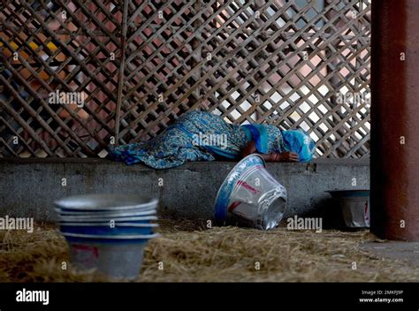 An Indian Woman Takes A Break As She Works At A Wholesale Fruit Market On A Hot Day In Hyderabad