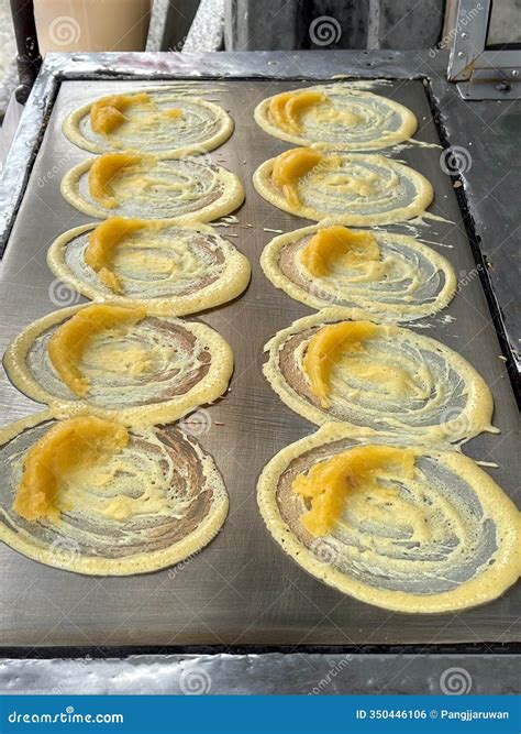 Delicious Circular Batter Cooking on a Hot Plate, Creating Golden