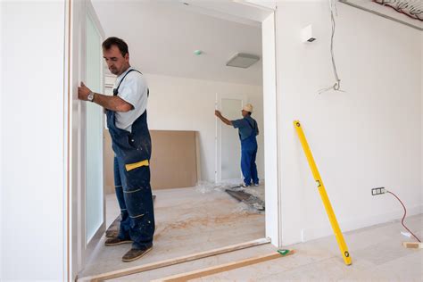 carpenters installing glass door with a wooden frame 11950017 Stock