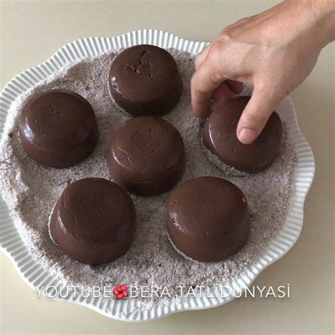 A Person Placing Chocolates On Top Of Each Other In A Paper Plate With