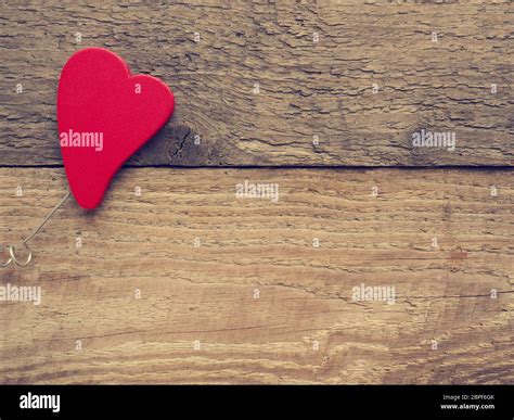 Red Wooden Heart Shape On A Rustic Plank With Space For Text