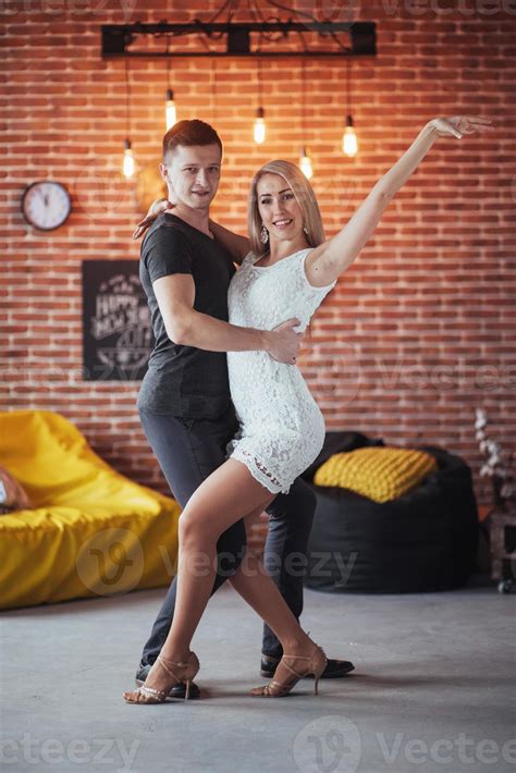 pareja joven bailando música latina bachata merengue salsa pose de dos elegancia en el café