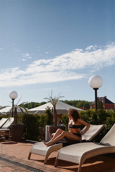 Attractive Female In Bikini Sitting On Sun Lounger By Stocksy Contributor Danil Nevsky Stocksy