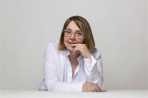 A Plump Mature Woman In Glasses And A White Shirt Is Sitting At The Table Stock Image Image