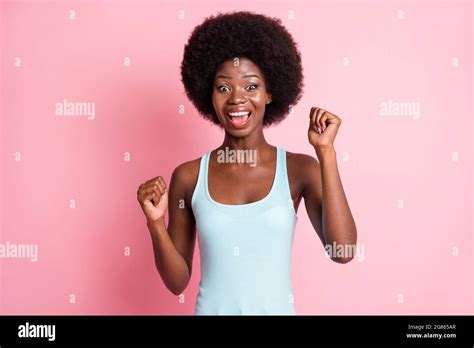 Portrait Of Hooray Brunette Curly Lady Hands Fists Wear Blue Top Isolated On Pastel Pink Color