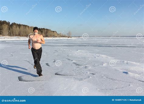 Man In A Cap With A Naked Torso Running Across The Ice Of A Frozen River Stock Image Image Of