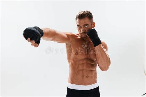 Man Athletic Bodybuilder Poses In Boxing Gloves With Nude Torso Abs In Full Length Background