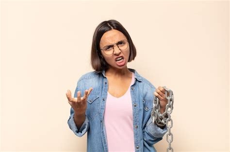Mujer latina joven que parece enojada molesta y frustrada gritando wtf o qué te pasa Foto Premium