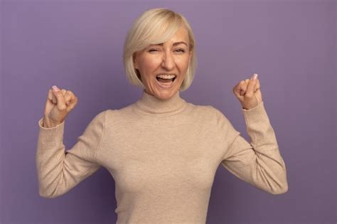 Joyeuse Jolie Blonde Femme Slave Se Tient Avec Les Poings Lev S Sur Violet Photo Gratuite