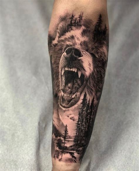 A Man S Arm With A Bear And Forest Scene Tattoo On The Left Forearm