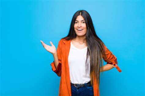 Joven mujer bonita latina sintiéndose feliz sorprendida y alegre sonriendo con actitud