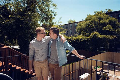Front View Of Gay Couple Standing In Balcony Against Trees Photograph By Cavan Images Fine Art