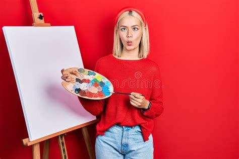 Beautiful Blonde Woman Standing Drawing With Palette By Painter Easel