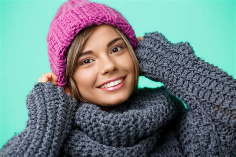 Belle Jeune Femme Blonde En Chapeau Et Pull En Tricot Souriant Sur Vert Photo Gratuite