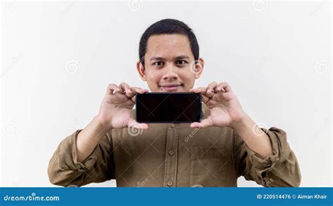 Smiling Face Expression Of Young Asian Malay Man Holding Smartphone