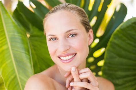 Premium Photo Beautiful Blonde Smiling At Camera Behind Leaf